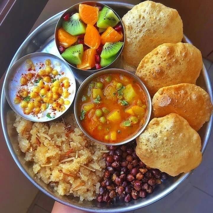 Traditional Indian thali with puri, curry, halwa, chana, and fresh fruit at Himalaya Restaurant in Daegu, South Korea